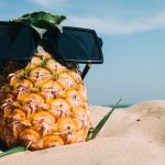 pineapple in sunglasses on the sand