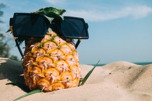 pineapple in sunglasses on the sand